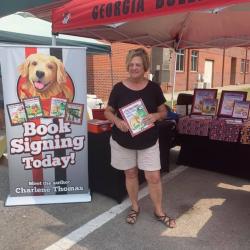 A woman holding a book near the book signing booth