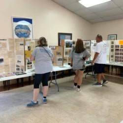 Visitors looking at exhibition stands with historical materials in a hall.